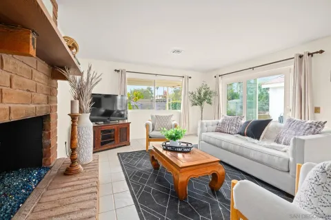 a living room with fireplace furniture and a floor to ceiling window