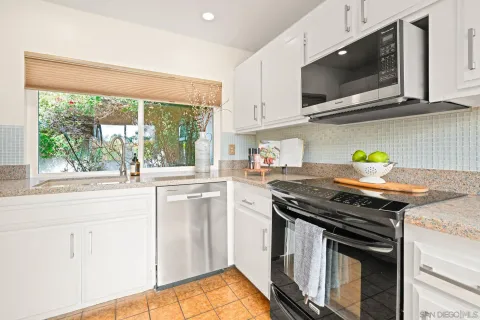 a kitchen with stainless steel appliances a stove a sink and a microwave