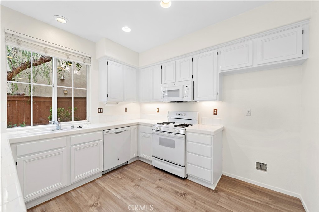 68 Kyle Court Ladera Ranch, CA 92694 - Photo 14 of 33 a kitchen with granite countertop white cabinets and white appliances