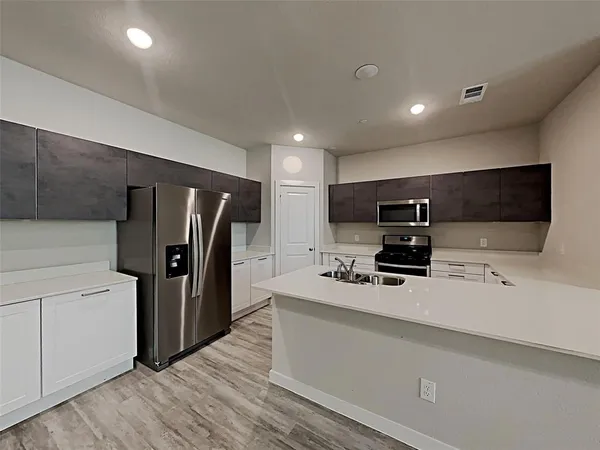 a kitchen with stainless steel appliances a refrigerator and a stove top oven