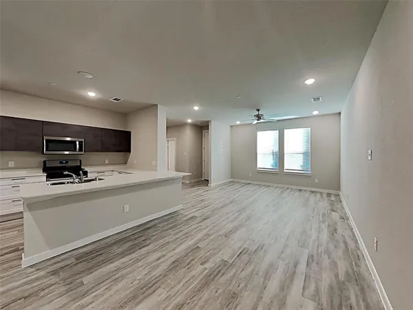 a view of kitchen with stainless steel appliances granite countertop a stove a sink and a refrigerator