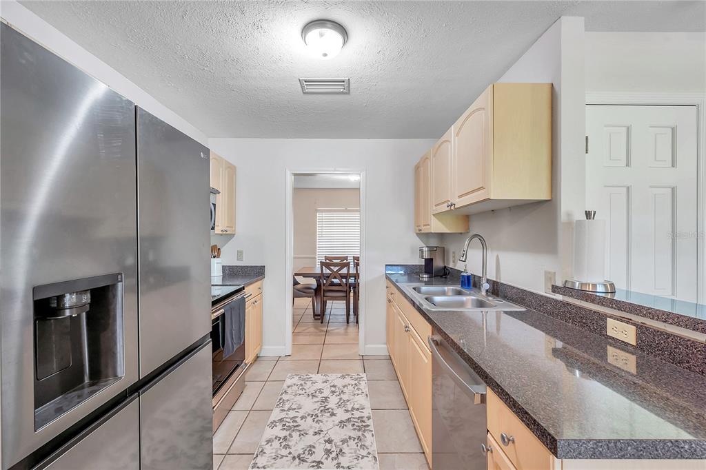 7405 Williams Road Seffner, FL 33584 - Photo 28 of 100 a kitchen with stainless steel appliances granite countertop a sink stove and refrigerator