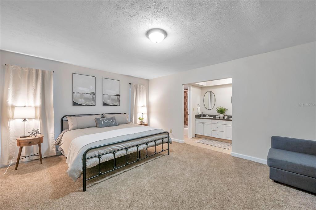 7405 Williams Road Seffner, FL 33584 - Photo 37 of 100 a spacious bedroom with a bed and a couch