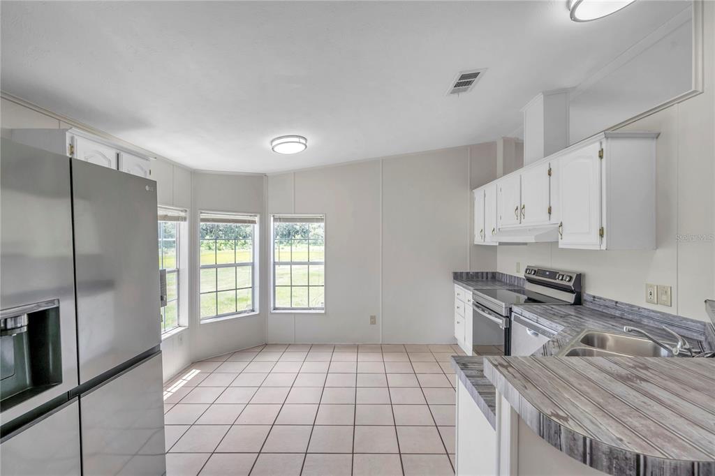 7405 Williams Road Seffner, FL 33584 - Photo 73 of 100 a kitchen with stainless steel appliances granite countertop a stove a sink and a refrigerator