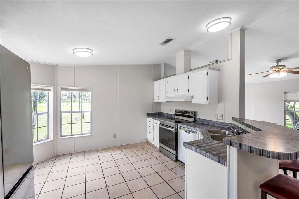 7405 Williams Road Seffner, FL 33584 - Photo 74 of 100 a kitchen with a stove a sink and a refrigerator