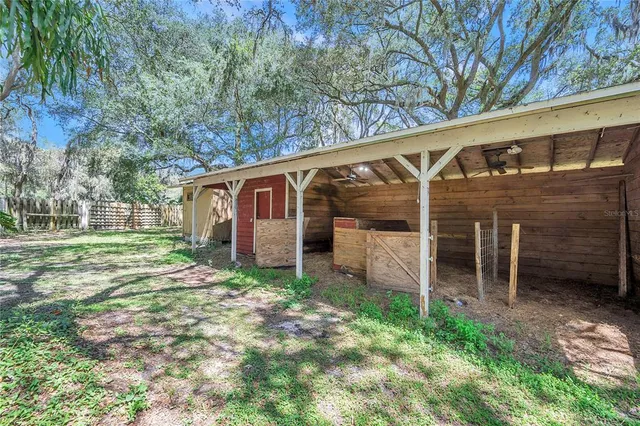 a kitchen with stainless steel appliances granite countertop a sink a stove top oven a chimney cabinets and living room view