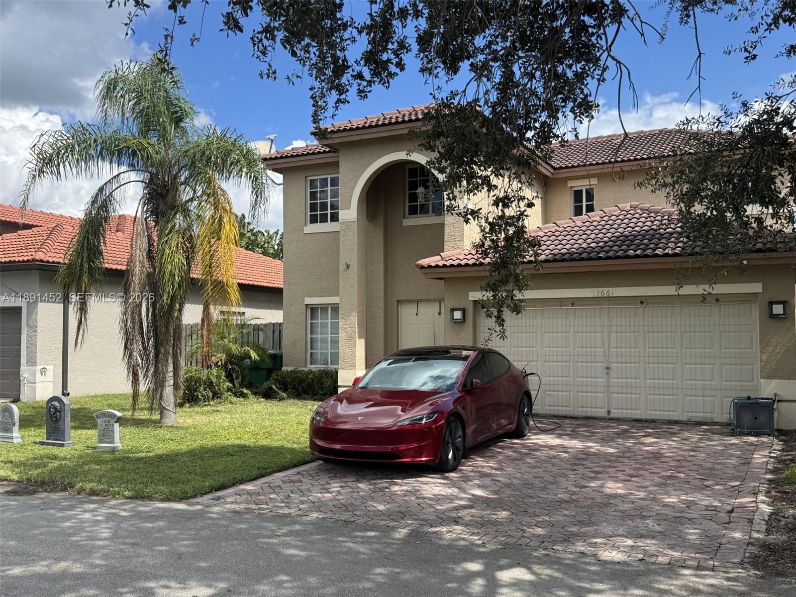 13661 Southwest 119th Avenue Miami, FL 33186 - Photo 2 of 36 a front view of a house with a garden and parking