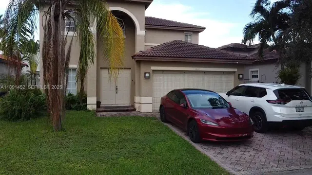 aerial view of a house with a yard and potted plants