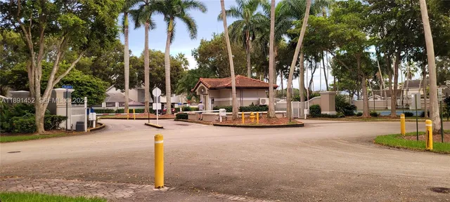 a view of a house with a yard and palm trees