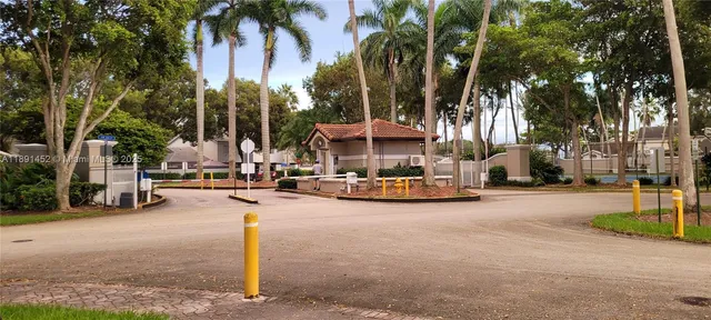 a view of a house with a yard and palm trees