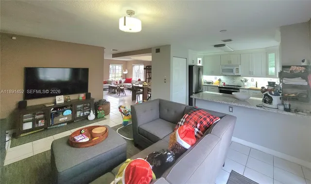 a kitchen with stainless steel appliances granite countertop a sink refrigerator and cabinets