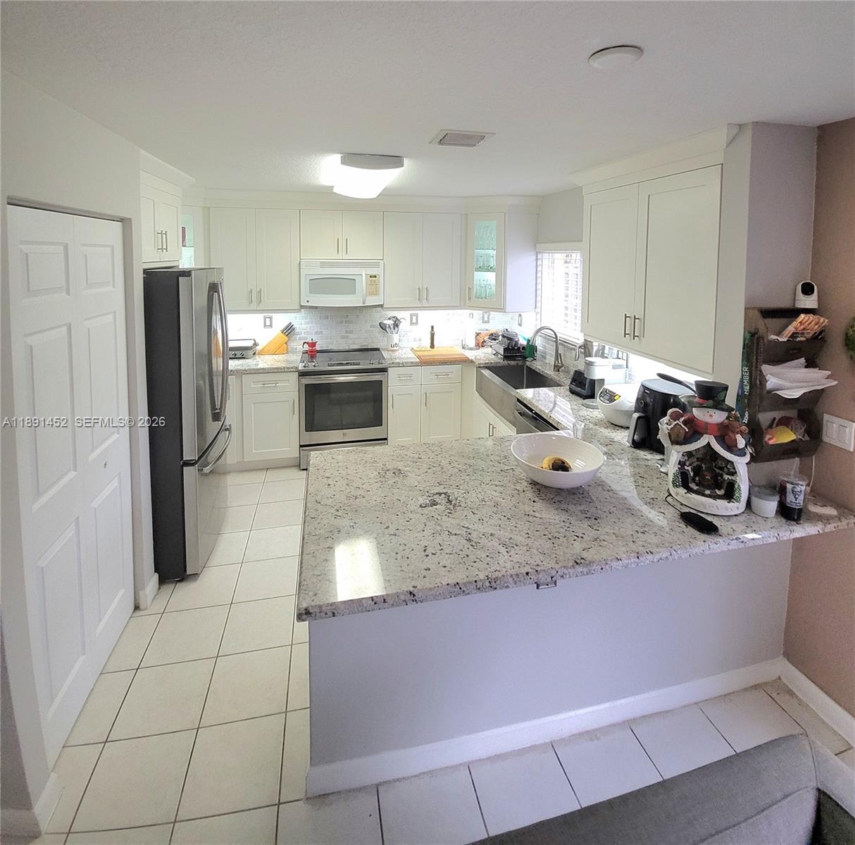 13661 Southwest 119th Avenue Miami, FL 33186 - Photo 7 of 36 a kitchen with stainless steel appliances granite countertop a sink refrigerator and cabinets