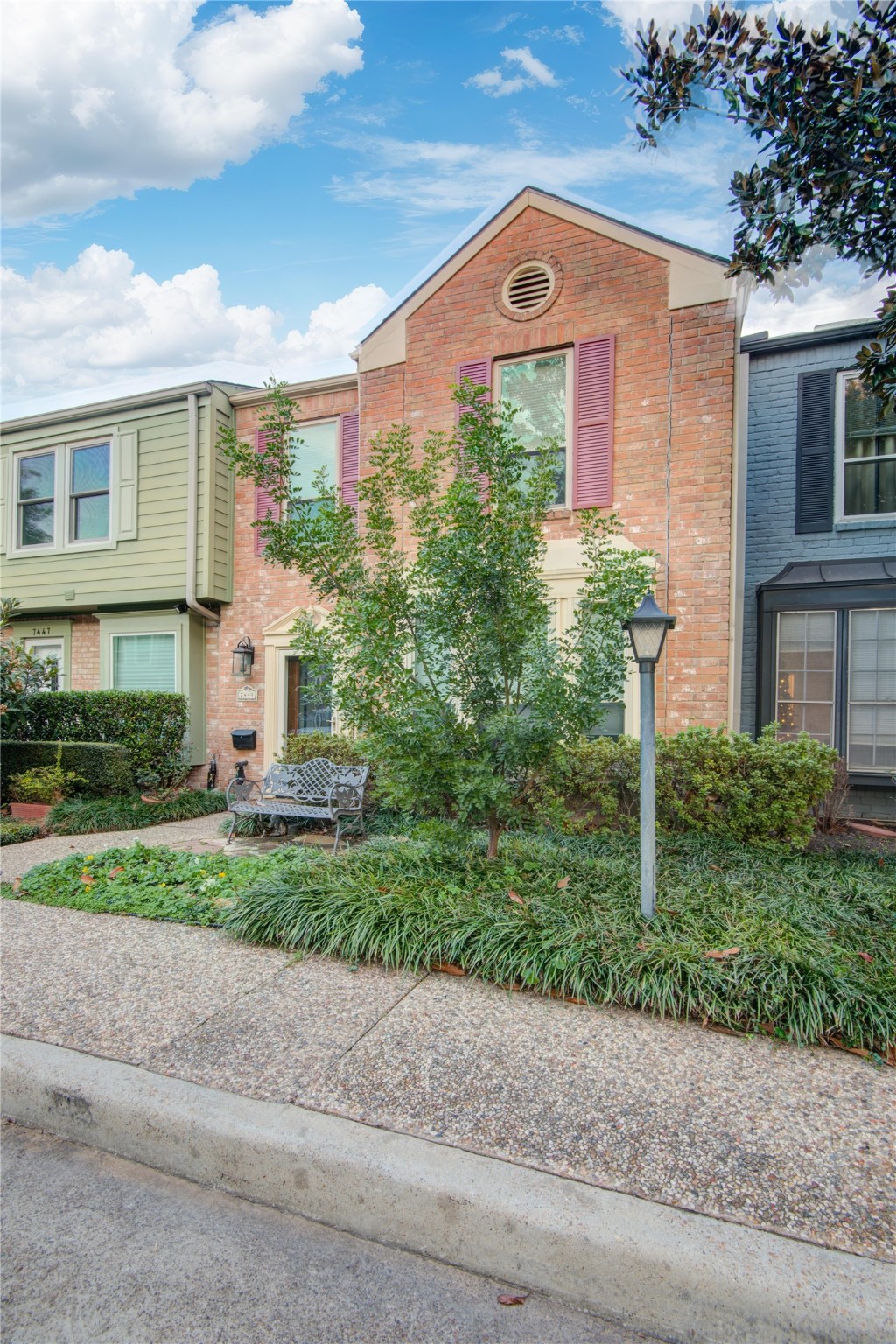 7449 Brompton Street, Unit 7449 Houston, TX 77025 - Photo 3 of 46 a front view of a house with a yard and a garage