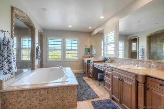 a large bathroom with a tub a sink shower and mirror