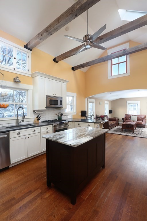 a kitchen with stainless steel appliances granite countertop a sink dishwasher stove and oven with wooden floor