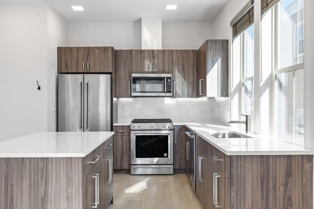 a kitchen with a stove a refrigerator and a sink