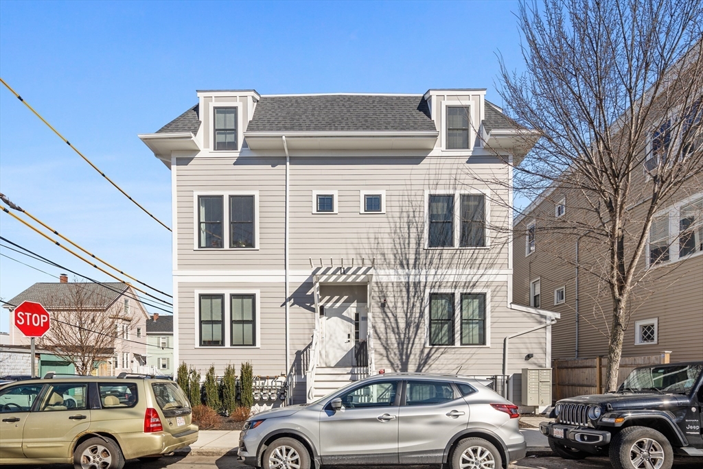 24 Rush Street, Unit G Somerville, MA 02145 - Photo 21 of 22 a front view of a building with parking space and a car parked car