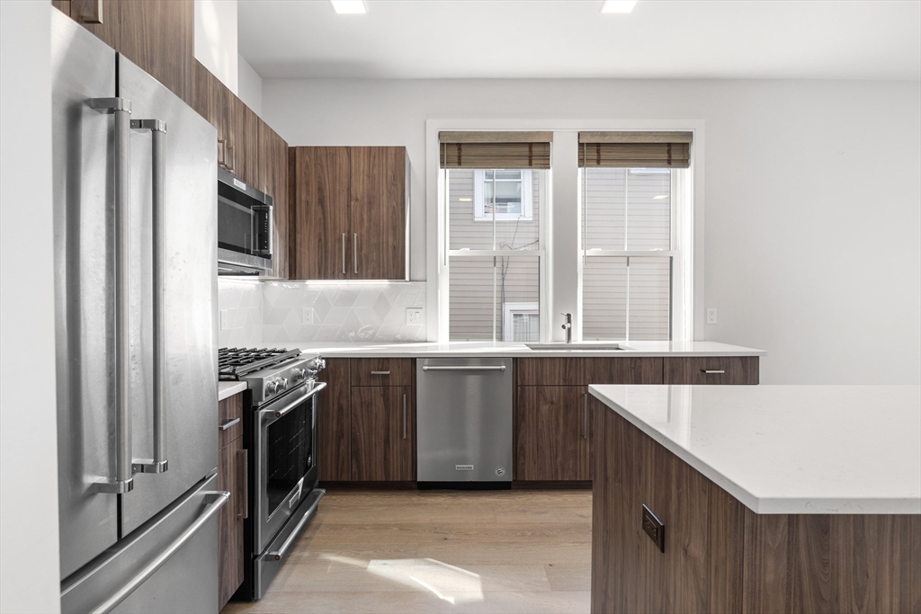 24 Rush Street, Unit G Somerville, MA 02145 - Photo 3 of 22 a kitchen with stainless steel appliances granite countertop a sink stove and refrigerator