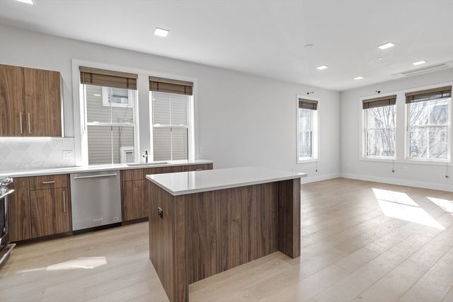 a open kitchen with granite countertop a sink and dishwasher with wooden floor