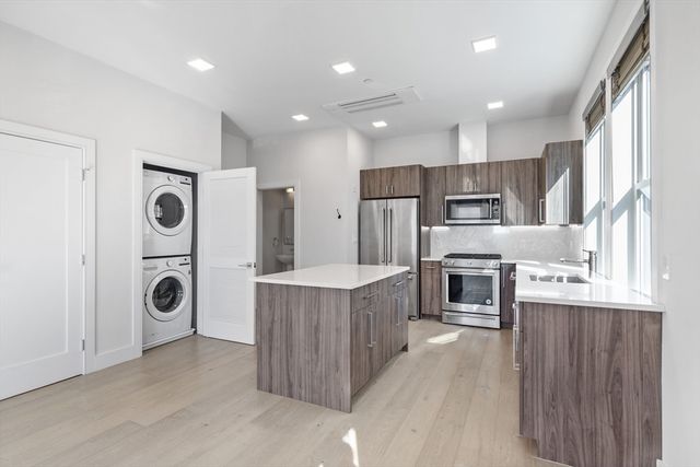 a kitchen with stainless steel appliances granite countertop a refrigerator a stove and a sink