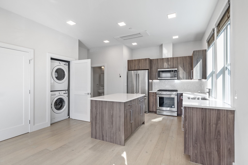 24 Rush Street, Unit G Somerville, MA 02145 - Photo 5 of 22 a kitchen with stainless steel appliances granite countertop a refrigerator a stove and a sink