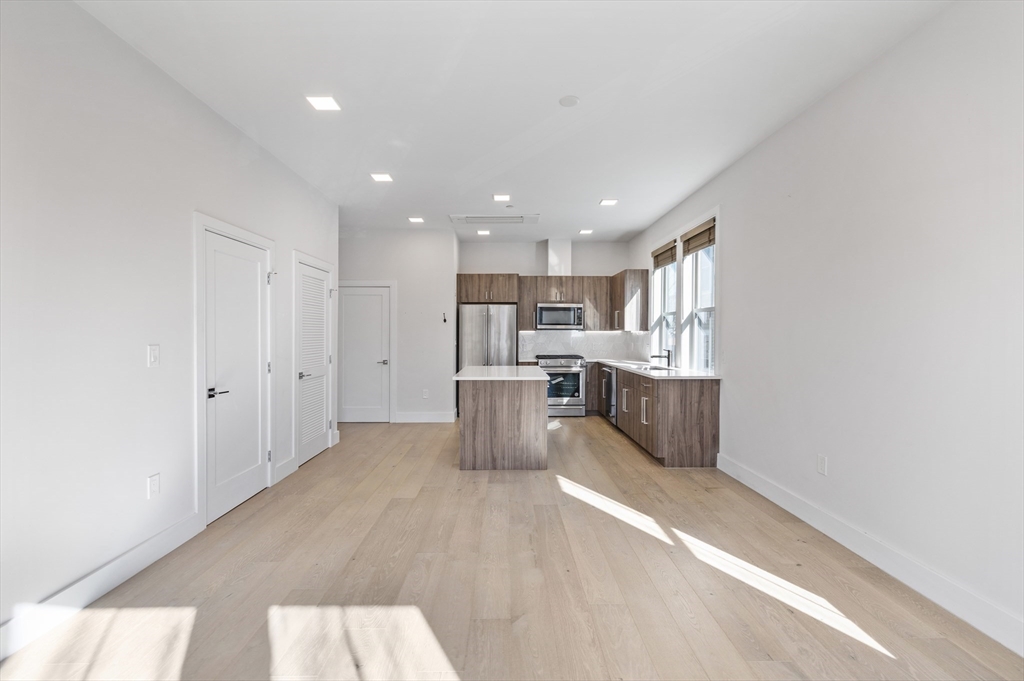 24 Rush Street, Unit G Somerville, MA 02145 - Photo 7 of 22 a kitchen with stainless steel appliances a refrigerator and a stove top oven