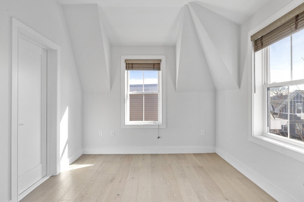 24 Rush Street, Unit G Somerville, MA 02145 - Photo 9 of 22 an empty room with wooden floor and windows