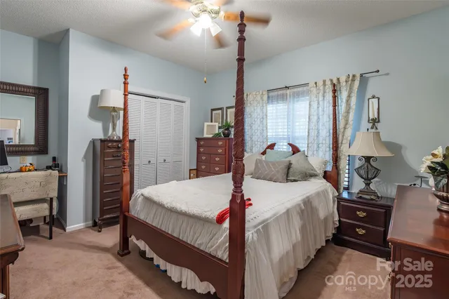a bedroom with a bed and large windows