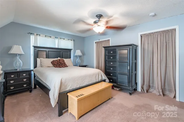 a bedroom with a bed a dresser and a chandelier