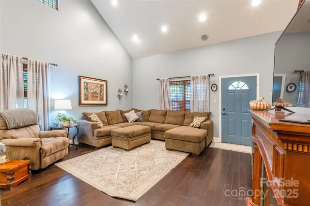 a living room with furniture wooden floor and a lamp