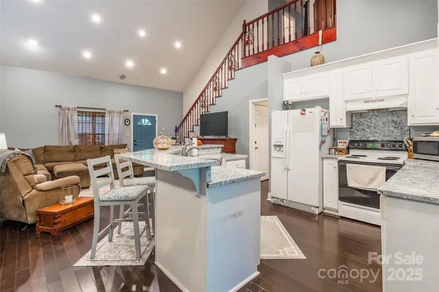 a living room with furniture and kitchen view
