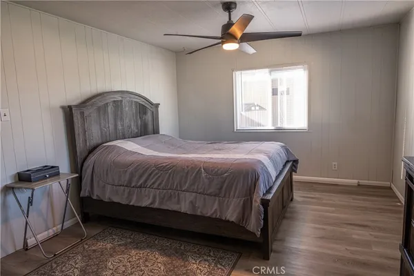 a bedroom with a bed and a flat tv screen on the dresser