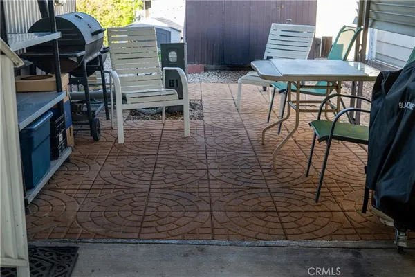 a view of a patio with table and chairs with wooden floor and plants