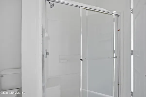 a bathroom with a glass shower door