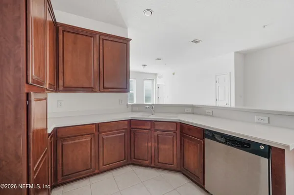 a kitchen with a sink dishwasher and wooden cabinets