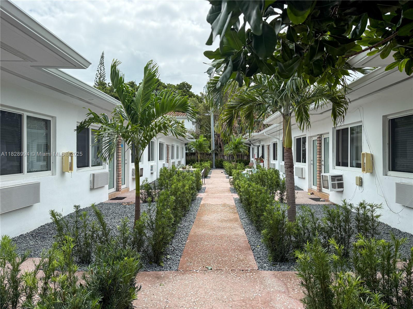 800 85th Street, Unit 794 Miami Beach, FL 33141 - Photo 13 of 13 a view of a house with a small yard plants and large tree