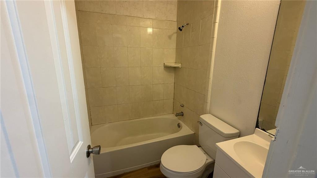 2714 West Mile 17 1/2 Road, Unit 18 Edinburg, TX 78541 - Photo 11 of 11 Full bath with vanity, shower / bathtub combination, a textured wall, and dark wood-style floors