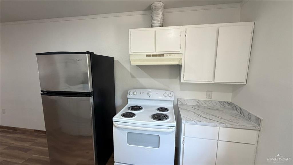 2714 West Mile 17 1/2 Road, Unit 18 Edinburg, TX 78541 - Photo 4 of 11 Kitchen with white electric range, white cabinetry, freestanding refrigerator, and light countertops