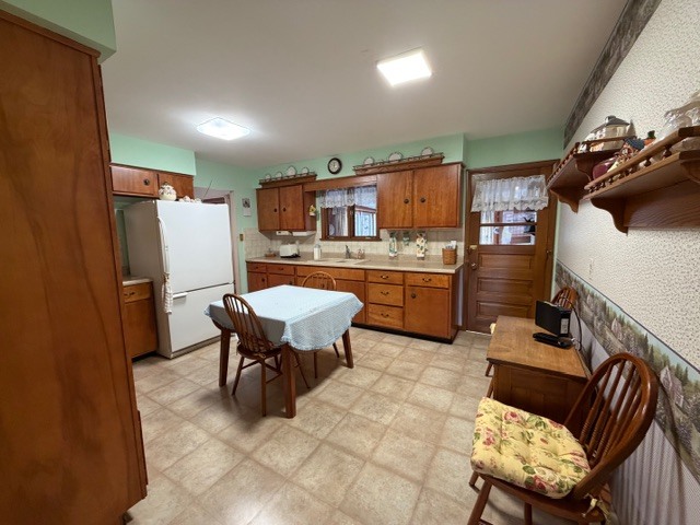 5563 Stone Drive Clinton, IL 61727 - Photo 14 of 34 a kitchen with a table chairs refrigerator and microwave