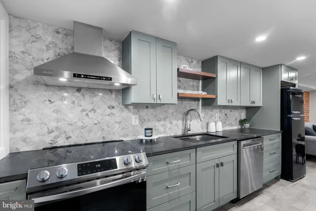 a kitchen with stainless steel appliances a stove and a sink