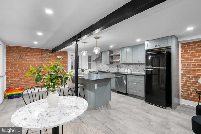 a kitchen with stainless steel appliances kitchen island granite countertop a refrigerator a sink a stove a dining table and chairs