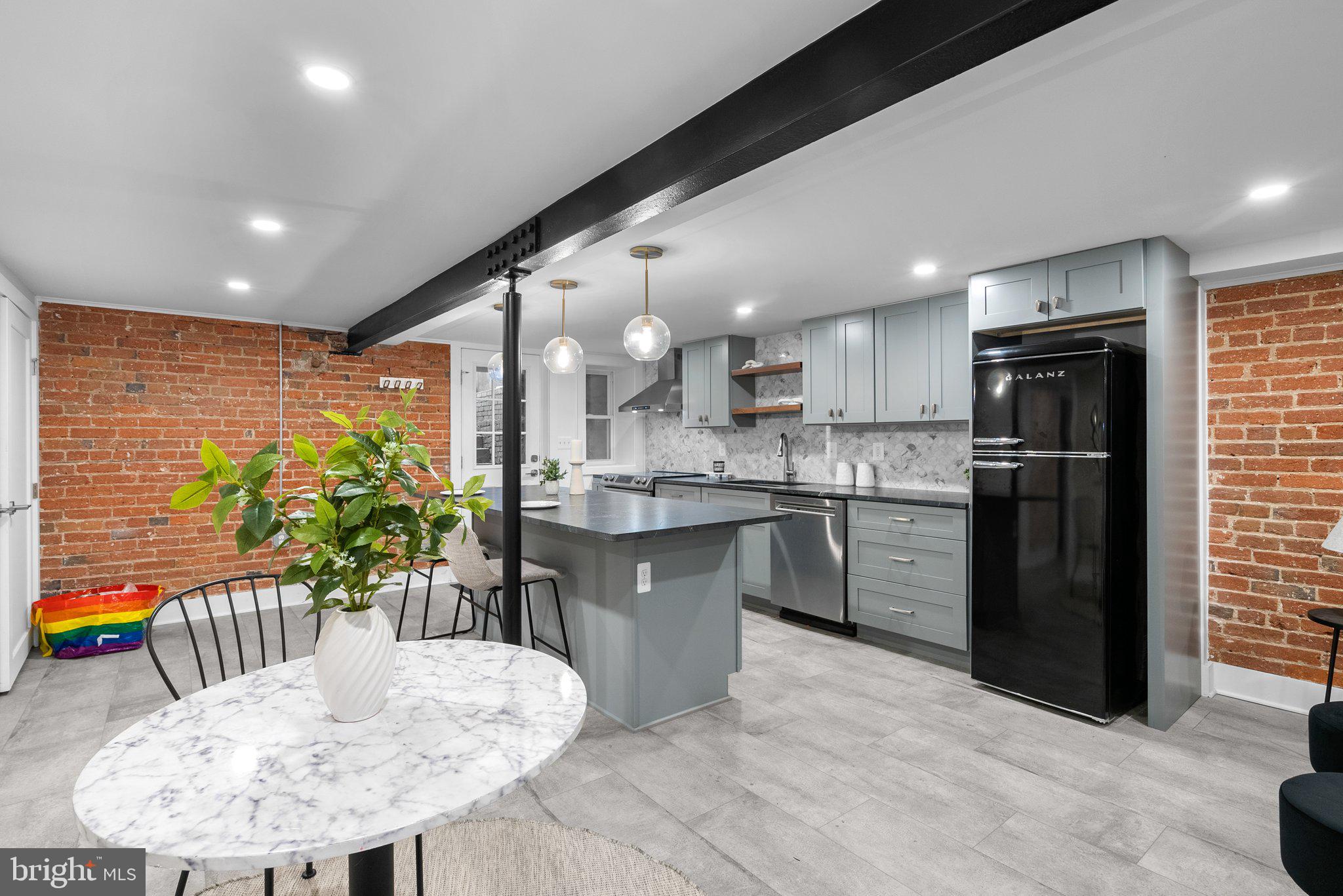 1616 Kilbourne Place Northwest Washington, DC 20010 - Photo 4 of 18 a kitchen with stainless steel appliances kitchen island granite countertop a refrigerator a sink a stove a dining table and chairs