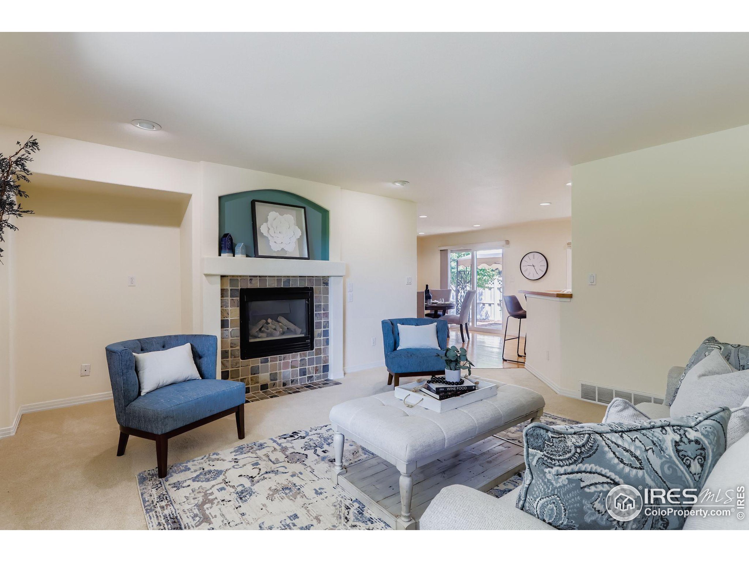 3600 Quail Road Longmont, CO 80503 - Photo 23 of 39 a living room with furniture a fireplace and a table
