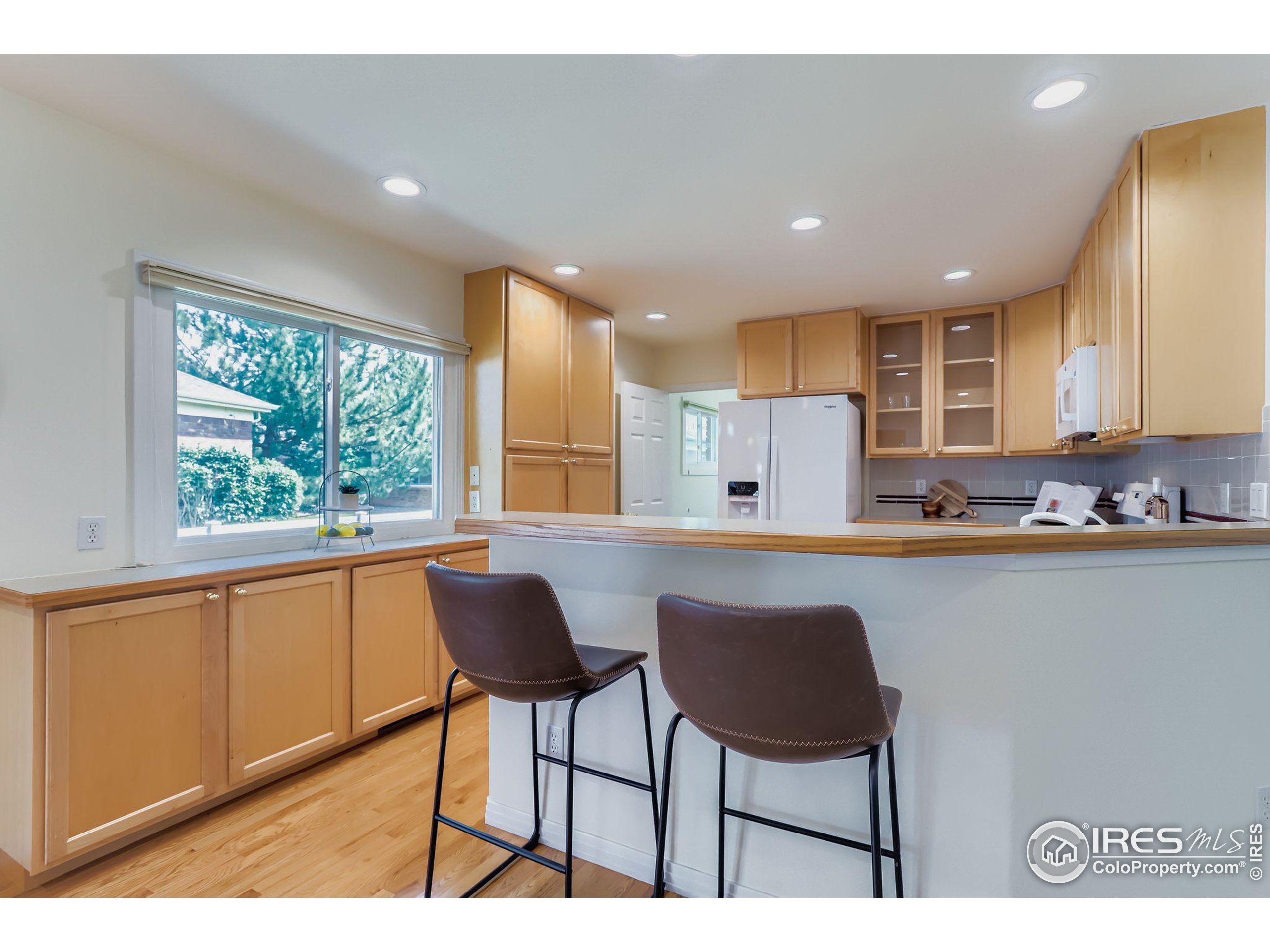 3600 Quail Road Longmont, CO 80503 - Photo 26 of 39 a kitchen with stainless steel appliances granite countertop a stove top oven a sink dishwasher and cabinets with wooden floor