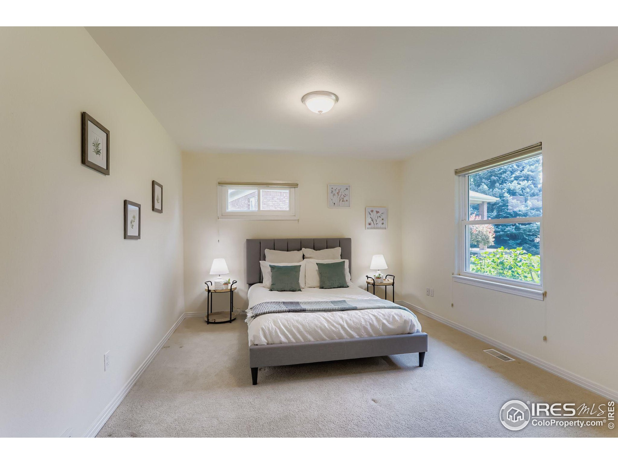 3600 Quail Road Longmont, CO 80503 - Photo 30 of 39 a bedroom with a bed lamp and a window