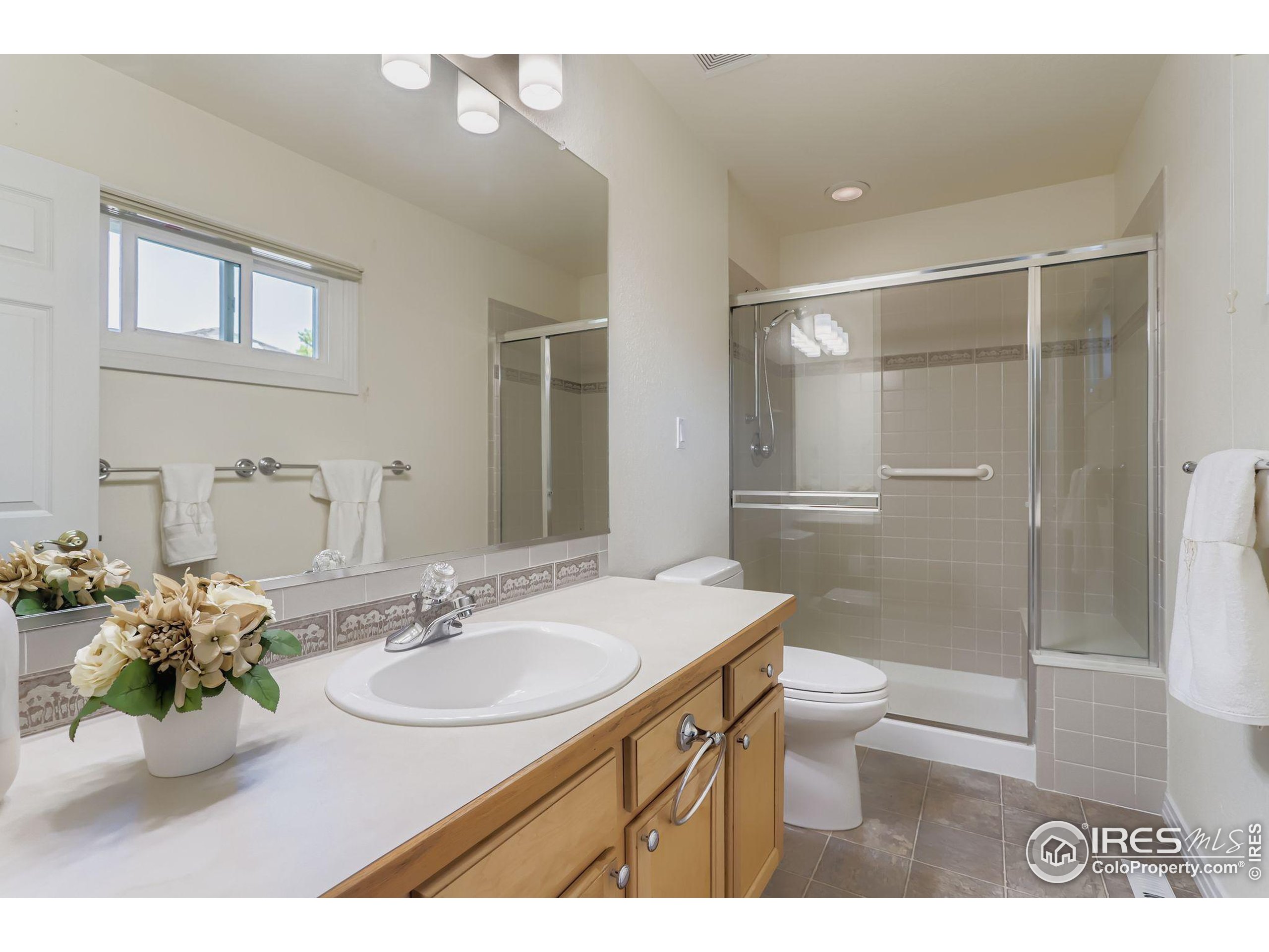 3600 Quail Road Longmont, CO 80503 - Photo 39 of 39 a bathroom with a sink toilet a mirror and shower
