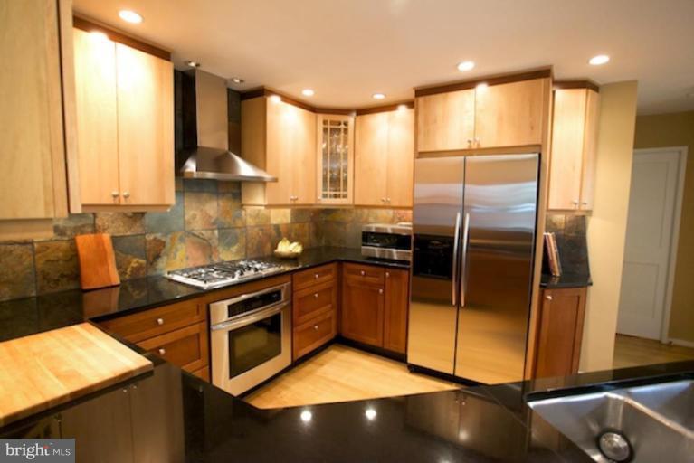 11601 Brandon Hill Way Reston, VA 20194 - Photo 3 of 27 a kitchen with stainless steel appliances granite countertop a refrigerator a sink a stove and white cabinets
