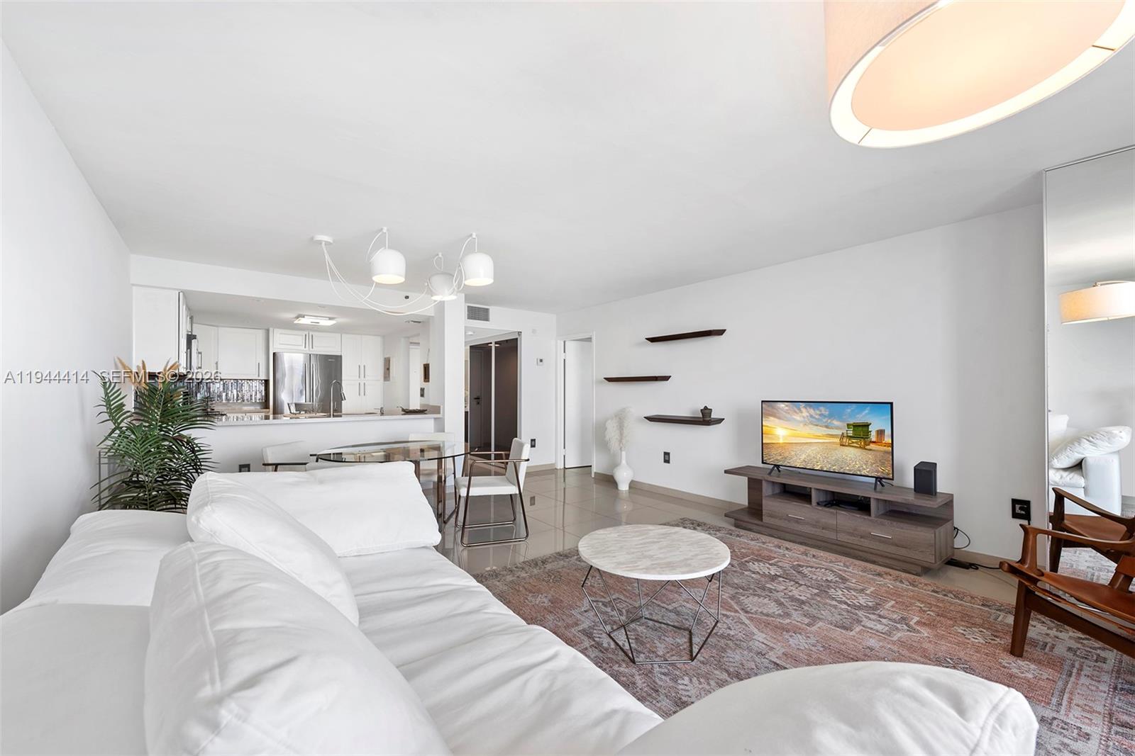 555 Northeast 15th Street, Unit 26B Miami, FL 33132 - Photo 6 of 18 a living room with furniture and a dining table