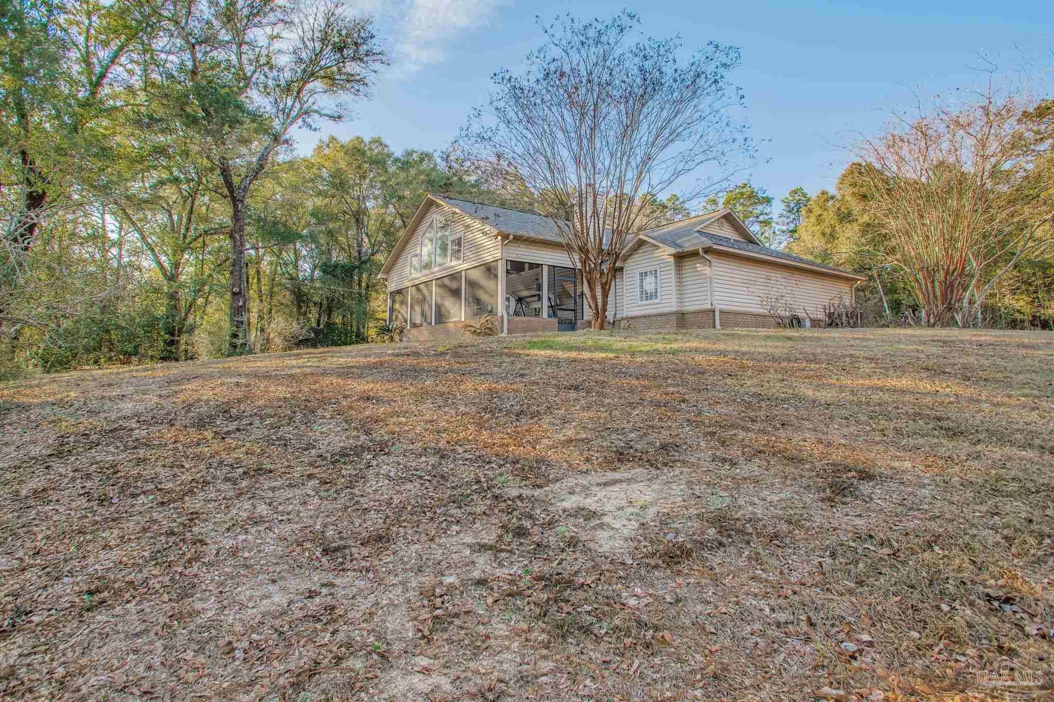 5150-5172 Siripon Road Milton, FL 32570 - Photo 24 of 54 a big house with a big yard and large trees