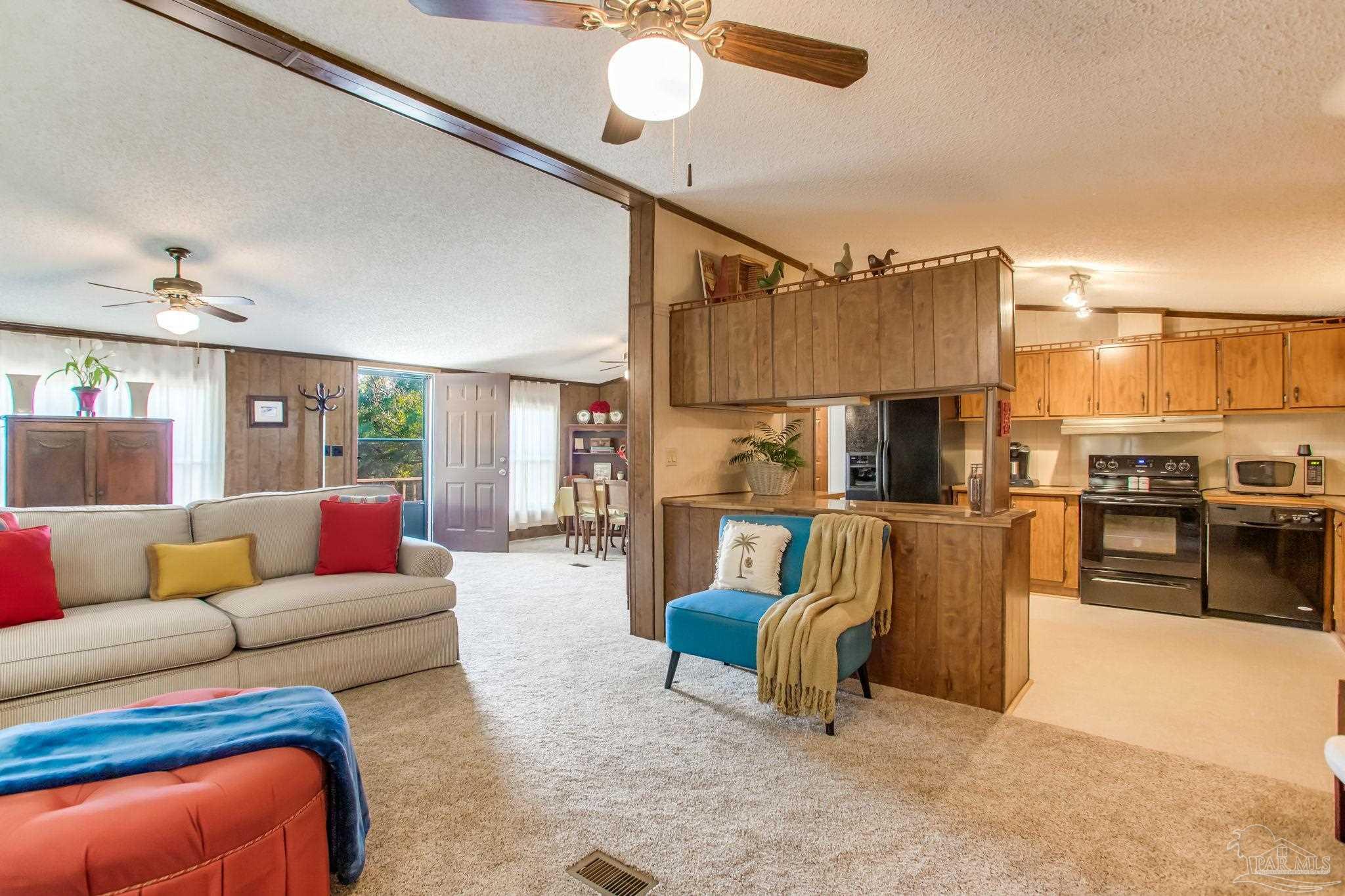 5150-5172 Siripon Road Milton, FL 32570 - Photo 26 of 54 a living room with furniture a kitchen island and a couch